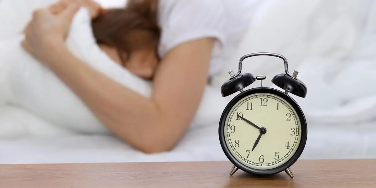 Une femme dans son lit présente des troubles du sommeil qui peuvent être liés à l'alimentation.